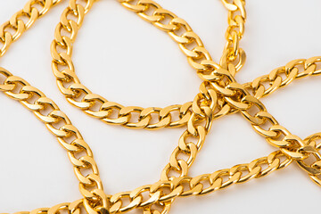 closeup of gold jewelry chains set on white background. 