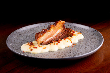 piece of pork belly on a bed of parmesan cheese