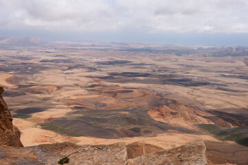 A desert landscape with a rocky outcropping in the foreground