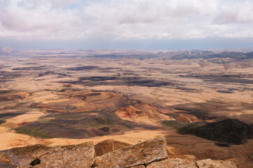 A desolate landscape with a few small hills and mountains in the distance