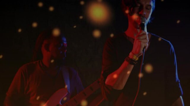 singer holding microphone and guitarist playing guitar on music stage with animated particles