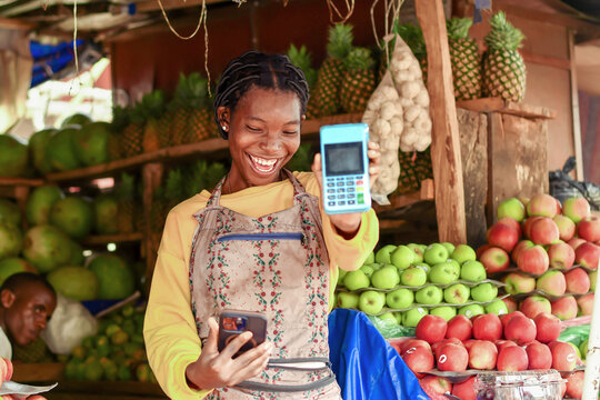 happy active fruit vendor receives mobile payment alert with nfc pos terminal