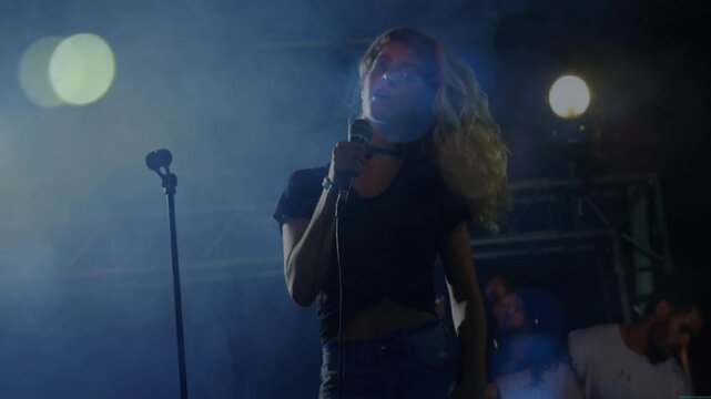 Lead singer gripping mic on smoky music stage, animated sound waves dancing under blue spotlights