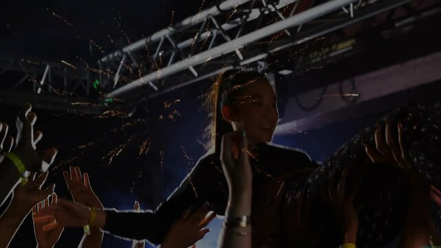 female performer stage diving during live music event, with animated confetti and light truss icons