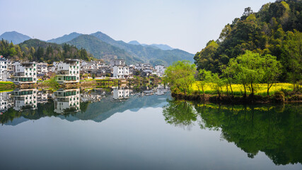 Picturesque Mountain Village Reflected in Calm Water