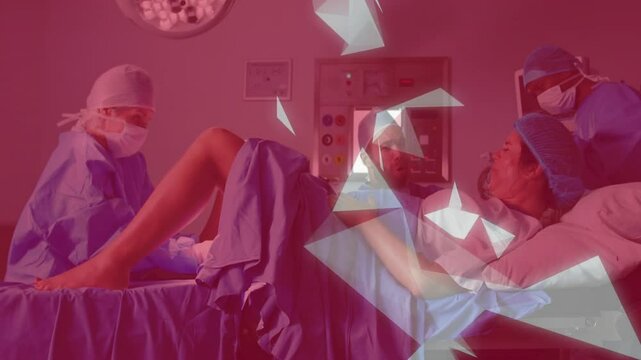 medical team supporting laboring woman in delivery room, with animated vital-signs graph overlay