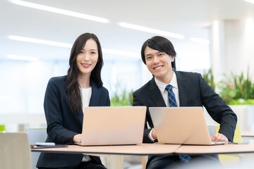 オフィスで打ち合わせをする若い男女のビジネスマン