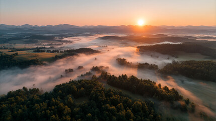 Fototapeta premium Aerial view of misty mountain landscape at sunrise with forest and hills perfect for background wallpaper