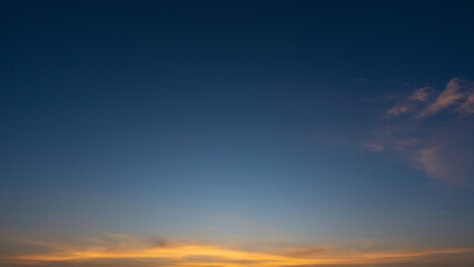 blue sky with soft wispy clouds at sunrise