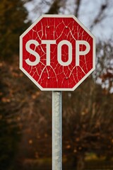 Stop sign with broken paint peeling