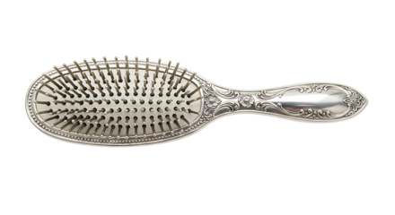 An ornate silver hairbrush with intricate floral details on a white surface