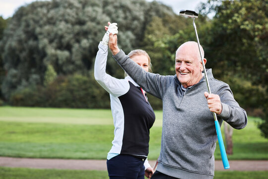 Senior man, golf and coach with high five, celebration and outdoor on a course and lawn. Fitness, club and woman instructor with sport, health and wellness with smile and target practice on vacation