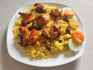 Nasi Biryani or Biryani Rice with honey roasted chicken on a white plate