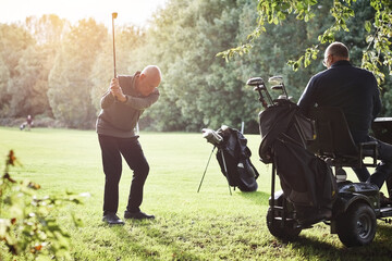 Sports, senior and person with disability for golf game, match and competition on golfing course. Recreation, mobility scooter and people swing club for training, fitness and practice on field © peopleimages.com