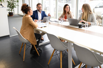 Confident professional lawyers discussing legal strategies and collaborative solutions in meeting...