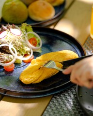 Savor a fluffy breakfast omelette with fresh salad at a cozy morning  gourmet food photography captures inviting atmosphere for a perfect start