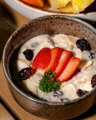 Delicious healthy breakfast bowl with strawberries and nuts cozy kitchen food photography warm atmosphere close-up view nutritional benefits