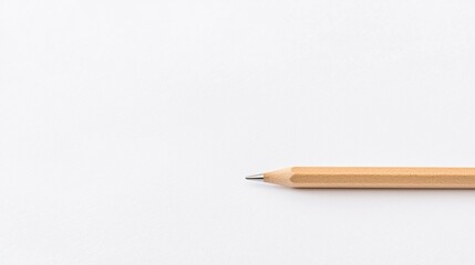 A simple wooden pencil rests on a blank, textured surface, highlighting minimalist design and the potential for creativity.