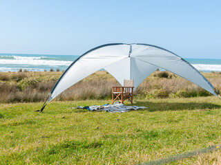 Sunshade erected on grass with beach background