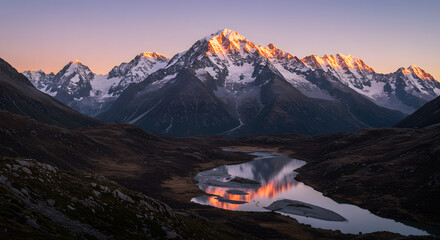 Obraz premium Scenic Mountain Peaks Reflecting Sunrise Light on Calm Alpine Lake