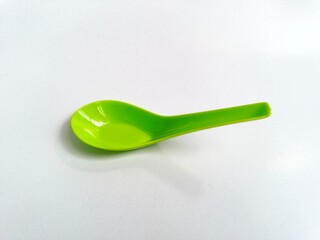 Green plastic spoon isolated on white background