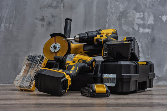 Professional cordless tool set. Angle grinder, screwdriver and impact wrench with batteries and tool box. Concept for construction, repair, renovation and DIY projects.
