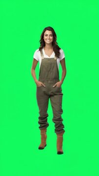 Smiling Woman in Overalls: A woman stands confidently, wearing overalls against a vibrant green background, radiating energy and positivity. 