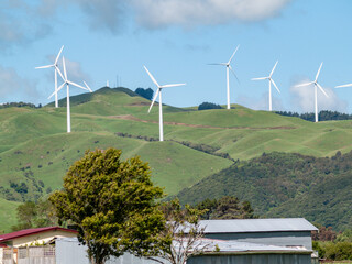White wind turbines over rural hills