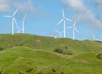 White wind turbines over rural hills