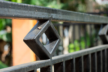 Close-up design of a black house fence made of iron columns.