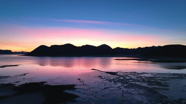 Aerial footage of Bleik, And&oslash;ya, showcasing steep cliffs, fjords, and the ocean during golden hour. Capturing the serene beauty of Arctic landscapes with vibrant sunset hues.