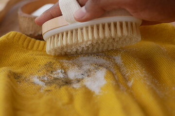 Caring for a yellow sweater using a brush and natural cleaner