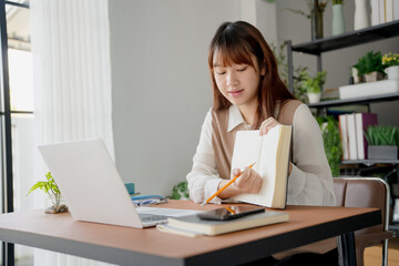 Asian woman using laptop to study student engaged in online learning at college