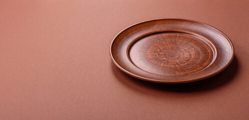 Empty ceramic plate on a monochrome brown background