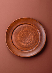 Empty ceramic plate on a monochrome brown background