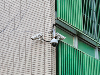 security cameras on pole with building in background.
