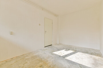 A bright and airy empty room featuring bare walls, a door, and sunlight casting shadows on the floor, creating a serene, minimalist space.