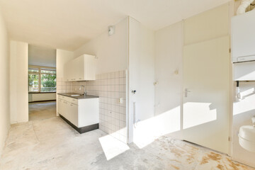 A bright and airy modern kitchen featuring minimalistic design elements, sleek cabinetry, and ample natural light from large windows.