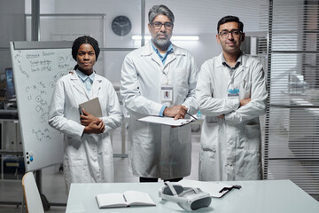 Portrait of scientists standing together in modern lab environment, displaying teamwork and...