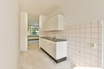 Spacious kitchen area featuring sleek cabinetry, simple countertops, and natural light streaming...