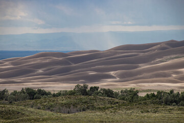 Fototapeta premium Natural beauty of rolling sand dunes under a cloudy sky in the desert landscape of late afternoon