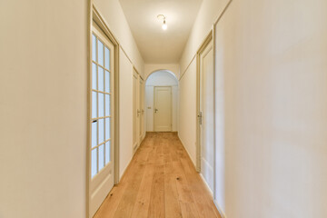 Bright hallway featuring white walls and wooden flooring, creating a serene and inviting atmosphere ideal for modern interiors.