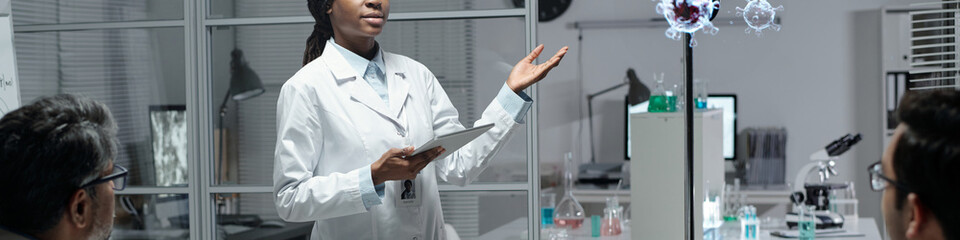 Scientist presenting advanced biomedical research findings in modern lab, engaging colleagues with...