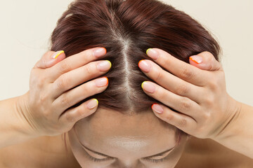 Naklejka premium 若いアジア人の女性は頭皮をマッサージしています。