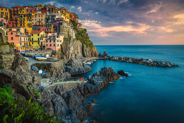 Village with colorful seaside houses on the cliffs at sunset