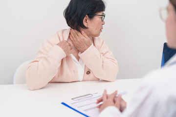 Elderly Woman having Shoulder and Neck and consulting doctor in hospital. Muscle painful due to...