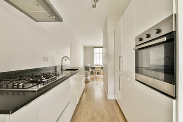 A sleek, modern kitchen featuring white cabinetry, a gas stove, and an integrated oven, with a light and airy ambiance, ideal for contemporary cooking spaces.
