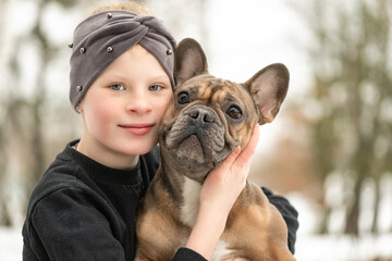 Portrait of a beautiful girl with a French Bulldog.