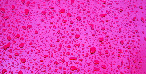 wide red purple background with the texture of rain drops on metal surface closeup