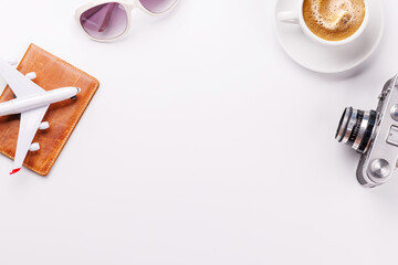 Travel-themed flat lay with toy airplane, camera, and coffee